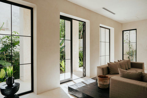 Expansive glass windows in the living room with lush greenery views