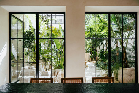 Tropical courtyard views through sleek dining area windows