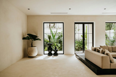 Stylish living space, potted plants and large windows with a garden view