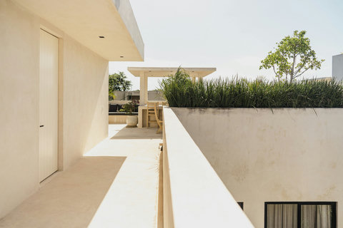 Rooftop balcony with railing and garden-framed lounge
