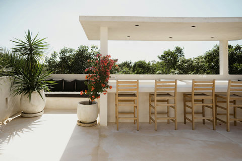 Rooftop balcony with stucco railing and garden-framed lounge