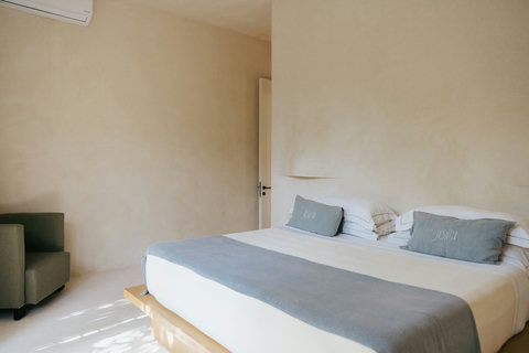 Light-filled bedroom featuring a cozy king bed