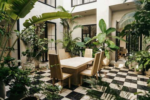 Elegant open-air dining on a white terrace with tropical accents