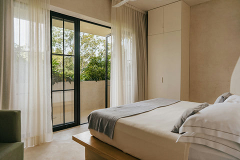 Spacious king bed with balcony access and lush garden view