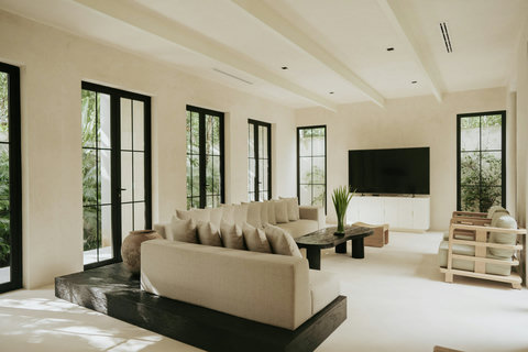 Living room with expansive glass windows overlooking lush greenery