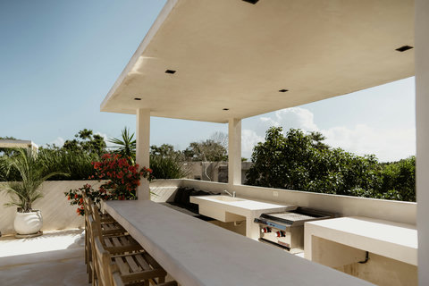 Rooftop lounge with bar stools, grill, and cozy seating