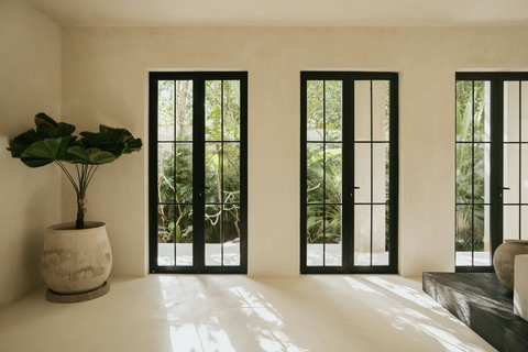Panoramic floor-to-ceiling windows overlooking vibrant greenery