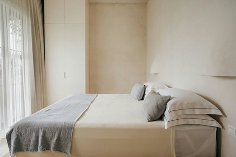 Calm bedroom featuring a platform bed and layered natural-toned curtains