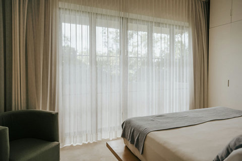 Peaceful bedroom with floor-to-ceiling curtains and cozy platform bed