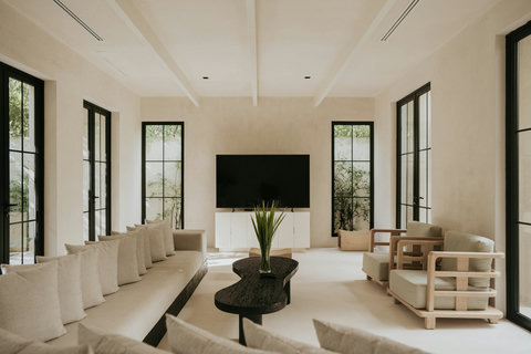 Sleek modern living room featuring a Smart TV and floor-to-ceiling garden views