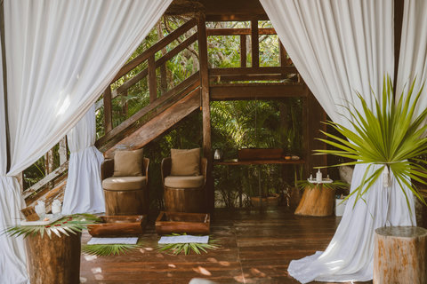 Behind soft white drapes, the spa opens like a hidden clearing, still, shaded, and made for unhurried exhale.