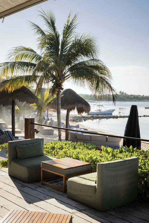 Beyond the terrace, palms sway lightly and the shoreline stays calm, inviting one more coffee before the day unfolds.