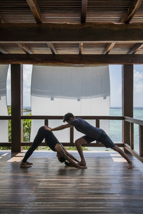 Hands guide the next breath deeper, balancing effort with trust while the ocean holds everything quiet and blue.