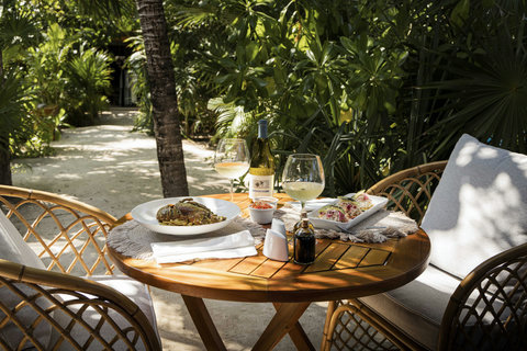 PANDANO RESTAURANT - Lunch lingers in the garden shade, where cool wine, easy conversation, and palms overhead keep everything feeling effortless.