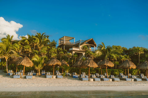 PRIVATE BEACH & BAY - Golden hour ignites resort silhouette against cobalt sky, beach cabanas ready for twilight cocktails and stargazing.