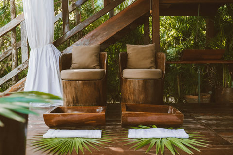 A private moment awaits in this shaded nook, where nature’s greenery wraps around warm wood.