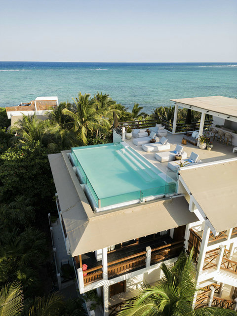 SWIMMING POOLS - Elevator doors open to a sky-level pool, glass edges floating between jungle green and wide-open ocean blue.