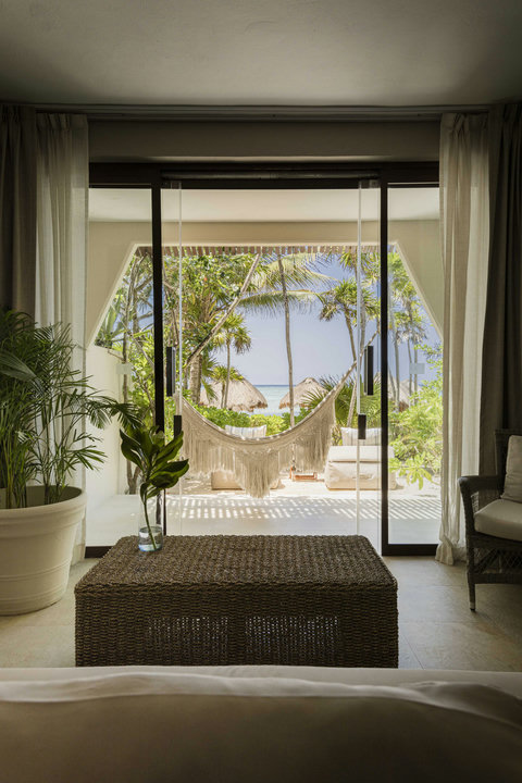 WATERFRONT SUITES - From sofa to shoreline in three steps, greenery frames the ocean like living artwork beyond glass.