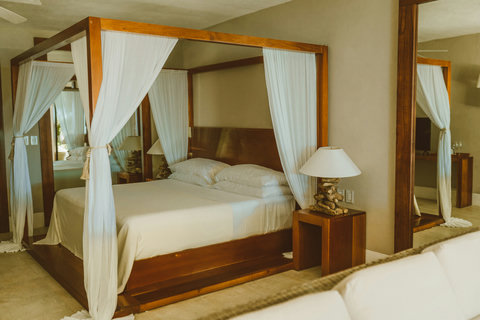 Slip behind gauzy curtains, four poster warmth invites quiet afternoon naps wrapped in driftwood tones and silk soft sheets.