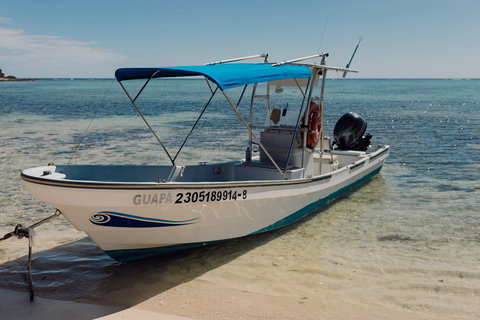 ADVENTURE SHACK - A small boat rests in crystal shallows, ready to carry you toward hidden coves and endless blue horizons.