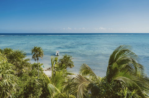 PRIVATE BEACH & BAY - Endless reef shimmers, a single boat drifts beyond breakers, horizon meeting sky in sweeping watercolour blues.