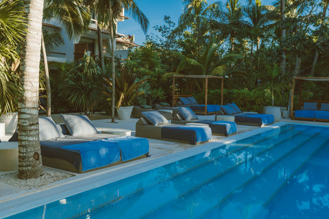 Tall palms lean over crystalline water, sky impossibly blue, calling for one last refreshing plunge before departure.
