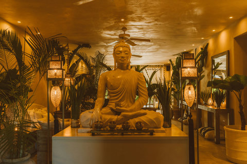 Golden lamps crown Buddha at center; air thick with copal smoke, evening reflection settles into mindful silence.