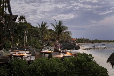 Twilight settles over the beach as candlelight flickers softly against the deepening ocean sky.