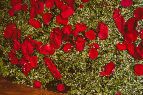 Vibrant rose petals rest upon dried herbs, creating a fragrant tapestry of color and scent.