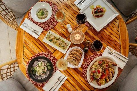 PANDANO RESTAURANT - A candlelit feast unfolds on warm wood, where shared plates and rich wines deepen the evening’s connection.