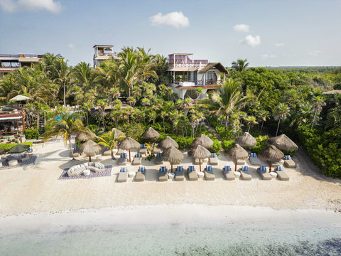 HOTEL VIEWS - Jungle edge hides terraces and pools, thatched umbrellas marking reserved sanctuary along whispering reef lagoon.