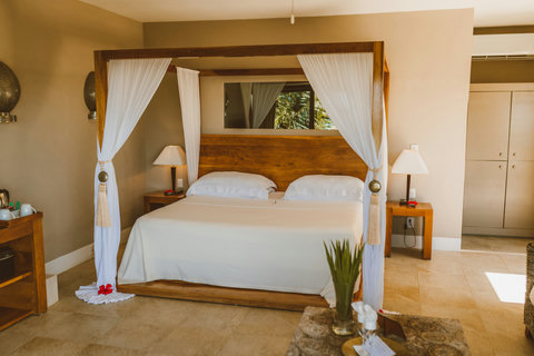 SUITE - Rest under the canopy of flowing muslin, feeling the gentle weight of the day lift as you sink into plush comfort and embrace the slow afternoon ease.