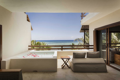 Slide into the private plunge pool as petals drift on warm water, your body suspended between sky and sea while the breeze carries salt and silence across your skin.