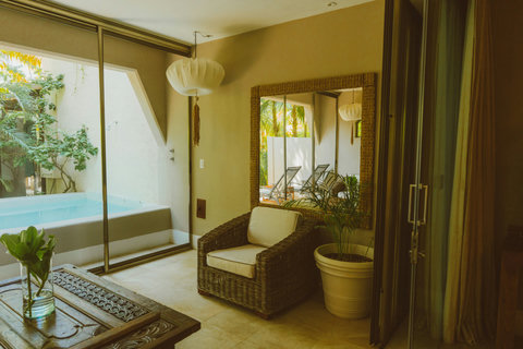SUPERIOR DOUBLE DELUXE SUITES - Sink into woven seating framed by geometric windows that frame lush greenery like living art, letting filtered sunlight and leafy whispers soften the edges of your day.