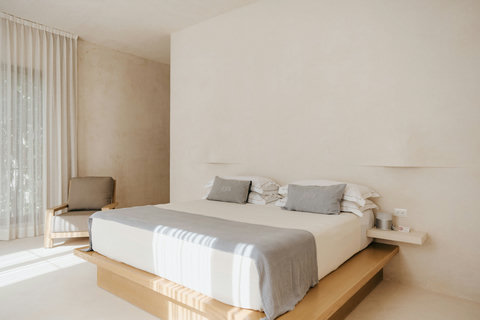 Light-filled bedroom with an accent chair and a king-sized platform bed