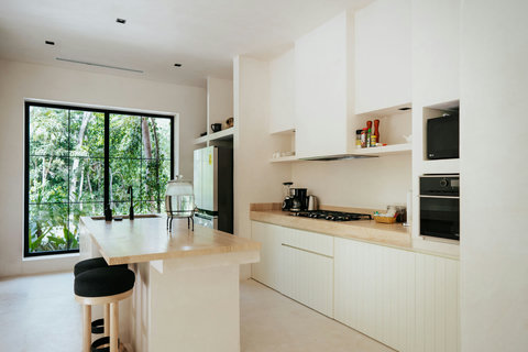 Modern open kitchen with black faucet and leafy vistas