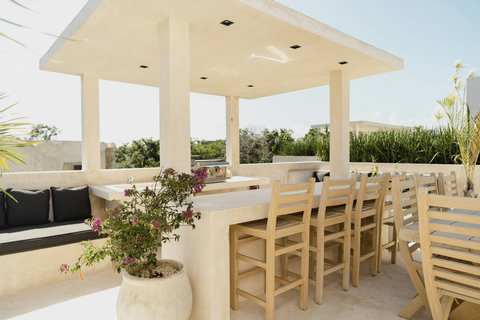 Sun-soaked rooftop with bar, grill, and cozy seating