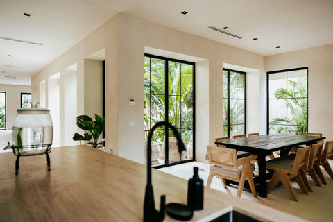 Bright dining area with natural wood chairs and scenic views