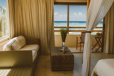 TWIN CROWNS ROYAL SUITE - Living room with oceanfront seating and natural light