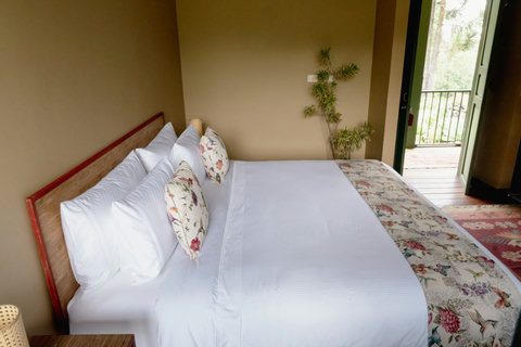 BEDROOM 1 - Step into serenity with this cozy retreat, where natural light dances through open doors and lush greenery soothes the soul. Unwind on plush, floral-accented bedding and enjoy a tranquil escape like no other.