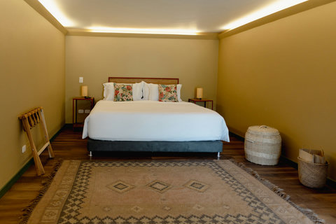 BEDROOM 1 - ✨ Bask in the warm, ambient glow of this cozy retreat, where every detail invites relaxation. Sink into the plush comfort of the king-sized bed, surrounded by earthy tones and lush textures. Perfect for unwinding and recharging. 🌿#SereneEscape