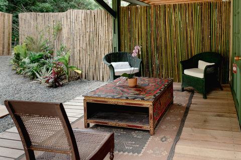 LIVING ROOM - 🌿 Step into serenity with this cozy outdoor nook, where bamboo accents and lush greenery create a tranquil retreat. The soft lighting invites you to unwind with a book or a cup of tea, perfect for lazy afternoons or intimate gatherings. 🌺✨ #