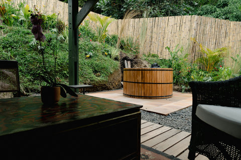 HOT TUB -  Unwind in your private garden oasis, where lush greenery meets rustic charm. Soak in the serene vibes with a relaxing hot tub experience, surrounded by nature's beauty and dappled sunlight. Bliss awaits.