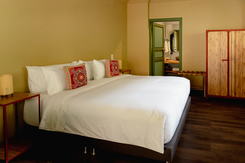 Bedroom 1 - Unwind in this cozy sanctuary, where warm, inviting tones and soft lighting create the perfect retreat. Sink into plush bedding adorned with vibrant pillows, and enjoy thoughtful amenities that ensure a relaxing stay. Your tranquil escape awai