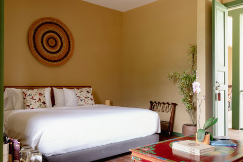 Bedroom - Step into serenity in this sunlit retreat featuring cozy earth tones and artistic flair. Unwind in the plush king-sized bed, surrounded by warm vibes and tranquil decor. A perfect blend of comfort and style awaits!