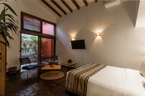 Bedroom 3 - Step into serenity and soak up the warm ambiance of this rustic retreat, featuring high-beamed ceilings and soft, inviting lighting. Relax in style and comfort with modern amenities, all nestled against a lush courtyard backdrop that promises