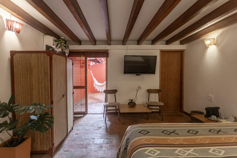 Beldroom 1 - Unwind in rustic charm and natural light, where warm wooden beams and cozy textures invite relaxation. Step onto your private terrace, hammock ready for lazy afternoons. Perfect for a serene retreat, all the comforts of home await.