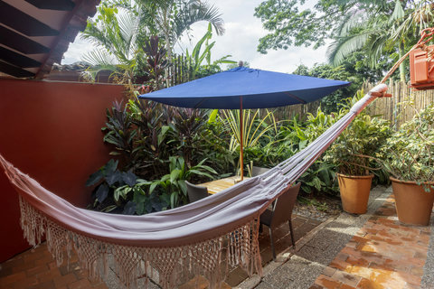 Patio - Unwind in a lush, tranquil oasis where the vibrant greenery and soft lighting invite pure relaxation. Sway in the hammock or enjoy alfresco dining under the shade of the umbrella, allowing nature to soothe your soul.