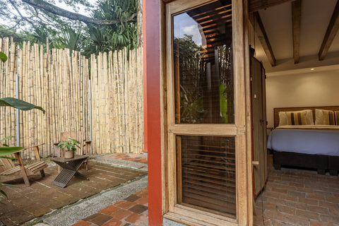 Patio - Escape to tranquility in this charming retreat, where rustic elegance meets nature's embrace. Bask in soft, natural light filtering through lush greenery as you enjoy your morning coffee on the private patio, complete with cozy seating. Relax in a