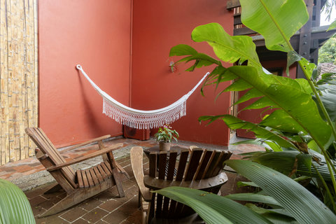 Patio - Escape to your own tropical oasis where tranquility meets style. Bask in the gentle breeze from the comfort of a handcrafted hammock, surrounded by lush greenery and warm, rustic wood. Enjoy serene evenings in this cozy patio retreat.